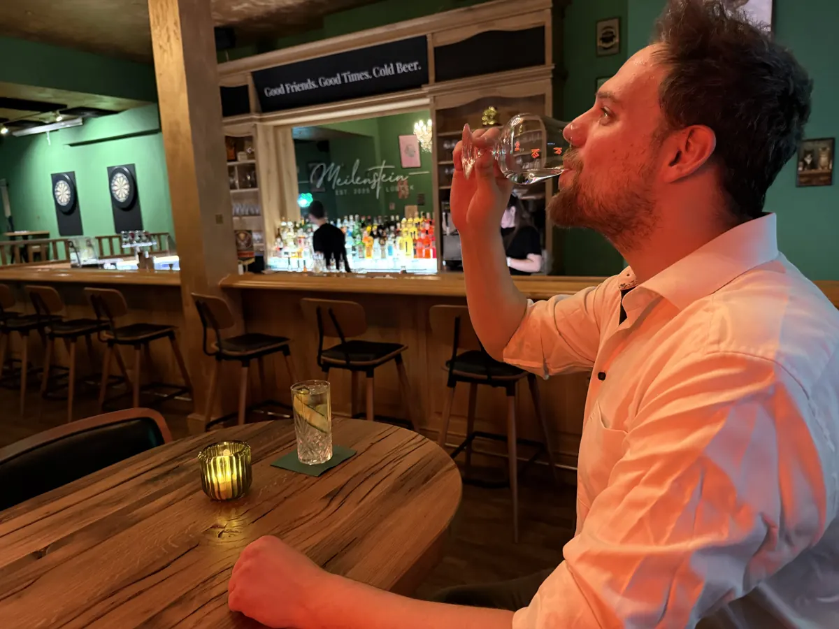 Ein Gast riecht konzentriert an einem Verkostungsglas in der Bar Meilenstein
