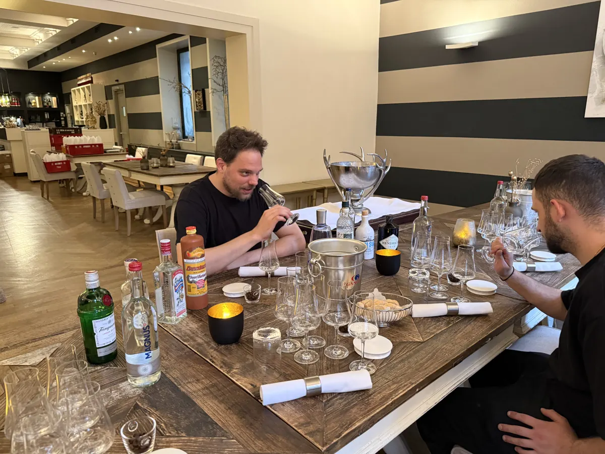 Zwei Gäste bei der Verkostung an einer Tafel mit Gin-Flaschen und Gläsern